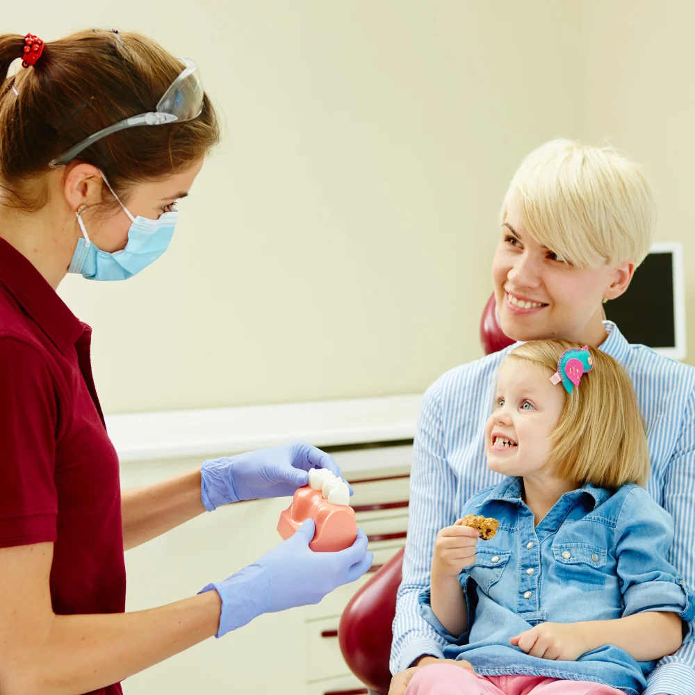 Young child being introduce by her parent to her Dentist, everyone is smiling