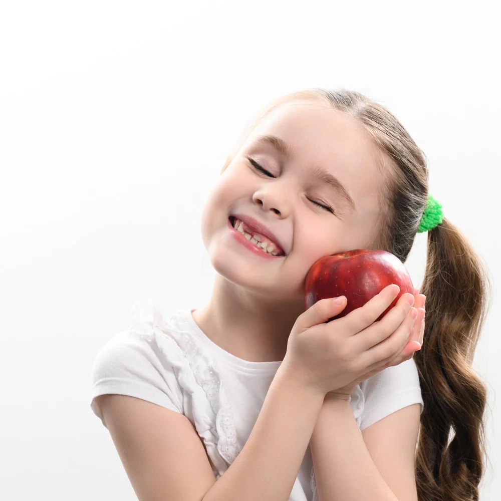 Young child holding an Apple and smiling